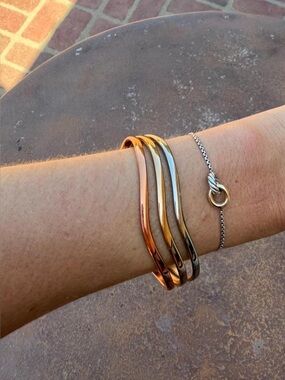Multi-colored cuff bracelet with three stacked metallic bands in rose gold
